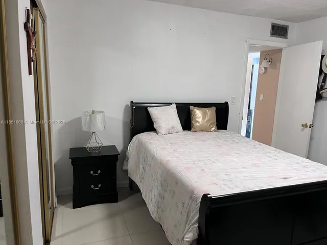 a spacious bedroom with a bed and a dresser