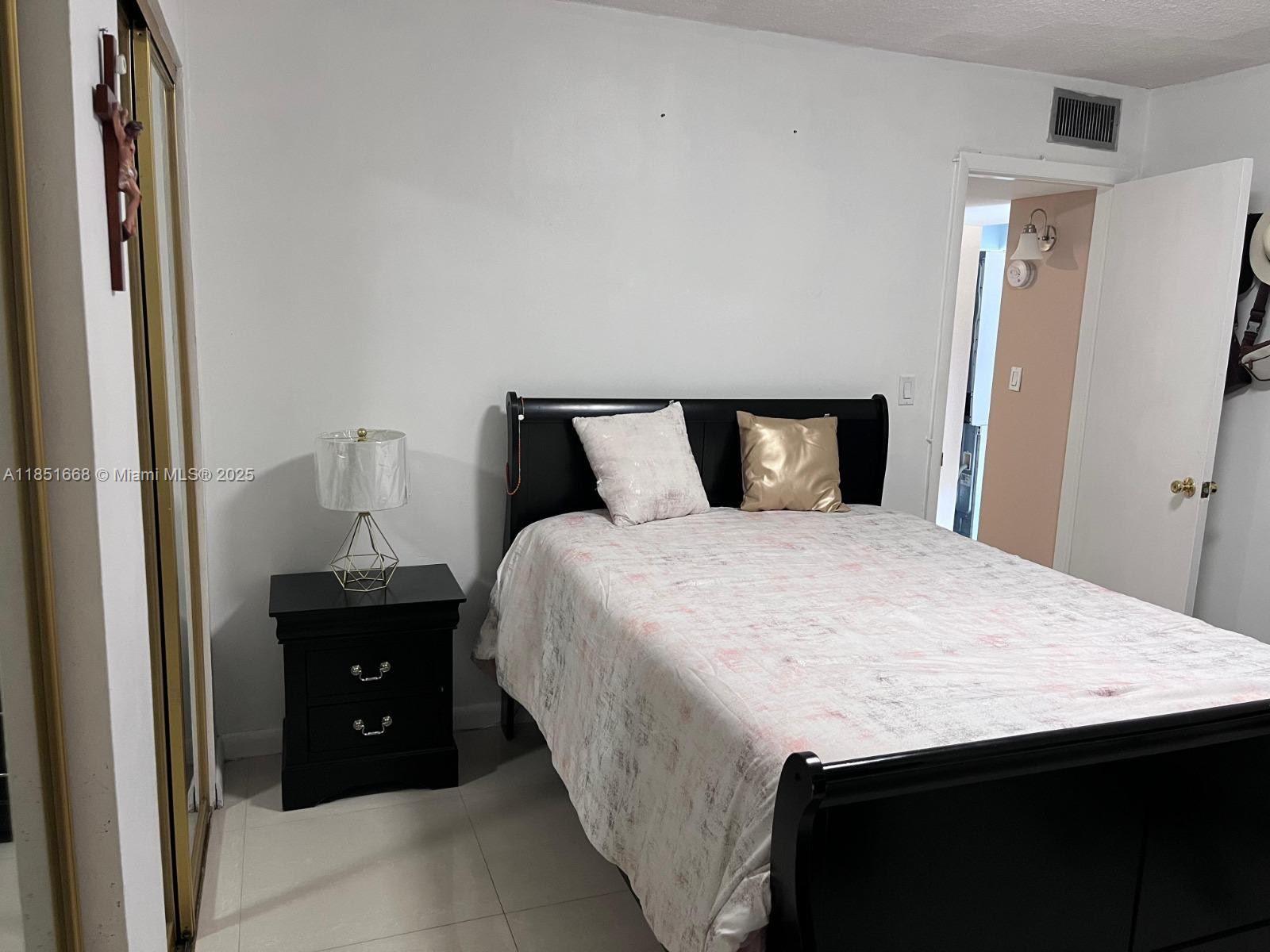 2496 Southwest 17th Avenue, Unit 5301 Miami, FL 33145 - Photo 8 of 19 a spacious bedroom with a bed and a dresser