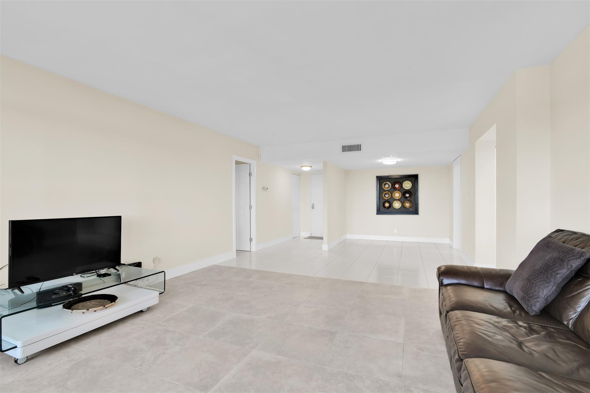 10777 West Sample Road, Unit 711 Coral Springs, FL 33065 - Photo 13 of 45 a living room with furniture and a flat screen tv