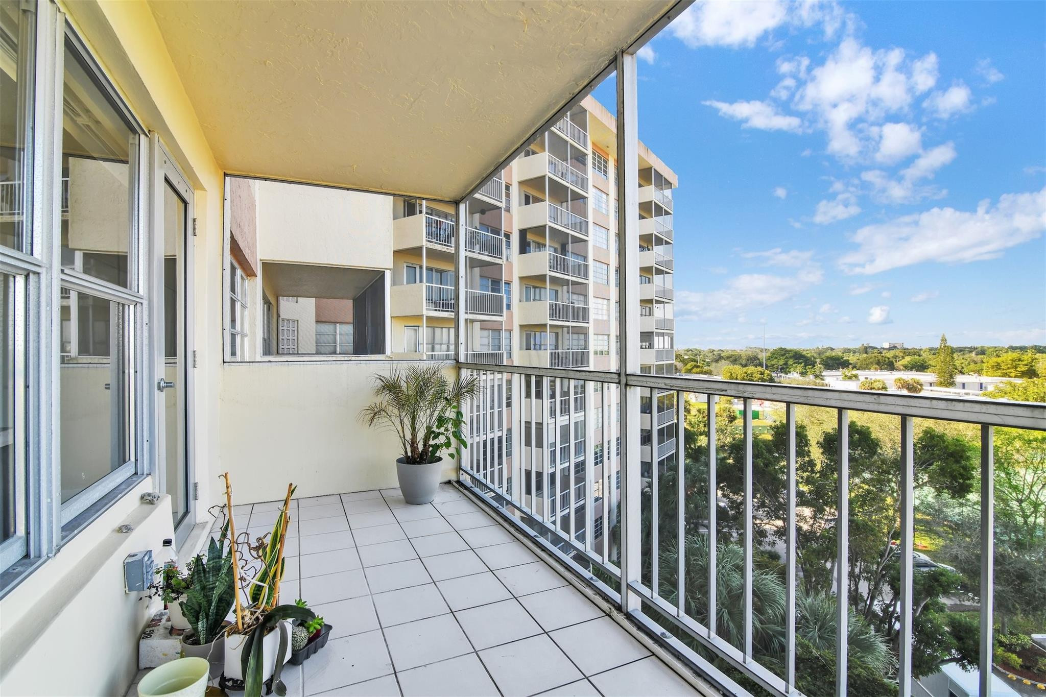 10777 West Sample Road, Unit 711 Coral Springs, FL 33065 - Photo 18 of 45 a view of a balcony with potted plants