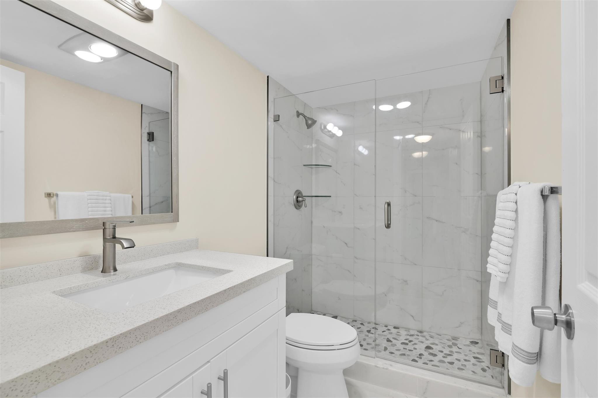 10777 West Sample Road, Unit 711 Coral Springs, FL 33065 - Photo 25 of 45 a bathroom with a sink toilet a mirror and shower