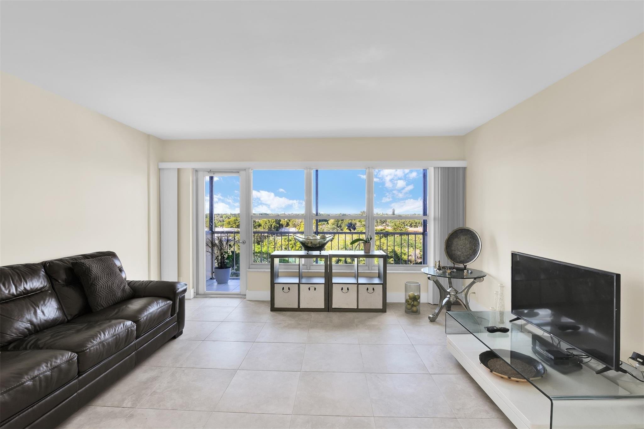 10777 West Sample Road, Unit 711 Coral Springs, FL 33065 - Photo 26 of 45 a living room with furniture a flat screen tv and a window