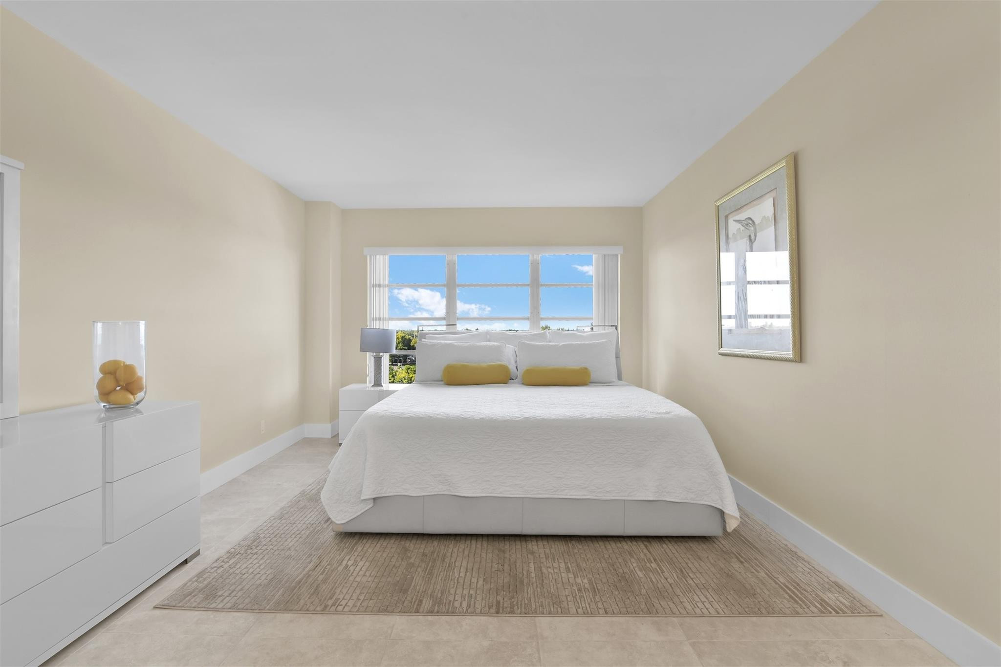 10777 West Sample Road, Unit 711 Coral Springs, FL 33065 - Photo 30 of 45 a large bed sitting in a bedroom next to a window and lamp