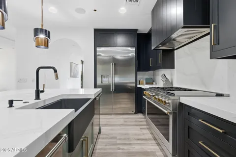 a kitchen with stainless steel appliances granite countertop a stove and a wooden floors
