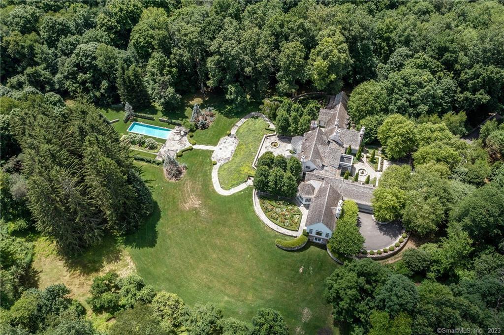 an aerial view of a house with swimming pool and lake view