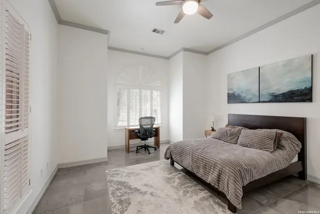 a bedroom with a bed lamps and chairs