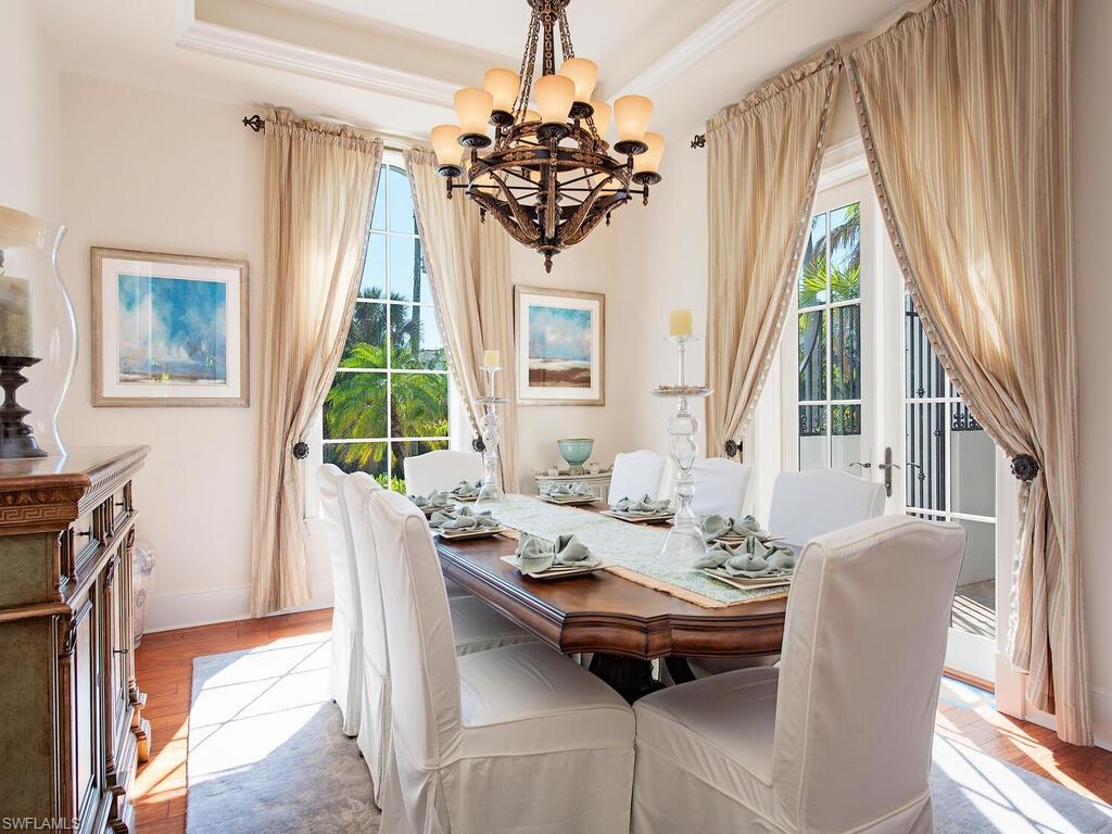 155 20th Avenue South Naples, FL 34102 - Photo 9 of 30 Dining area featuring a chandelier, a raised ceiling, and light wood finished floors