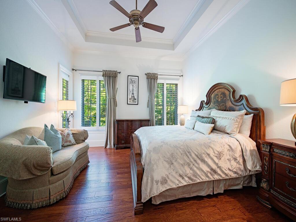 155 20th Avenue South Naples, FL 34102 - Photo 10 of 30 Bedroom featuring hardwood / wood-style flooring, a raised ceiling, crown molding, and ceiling fan