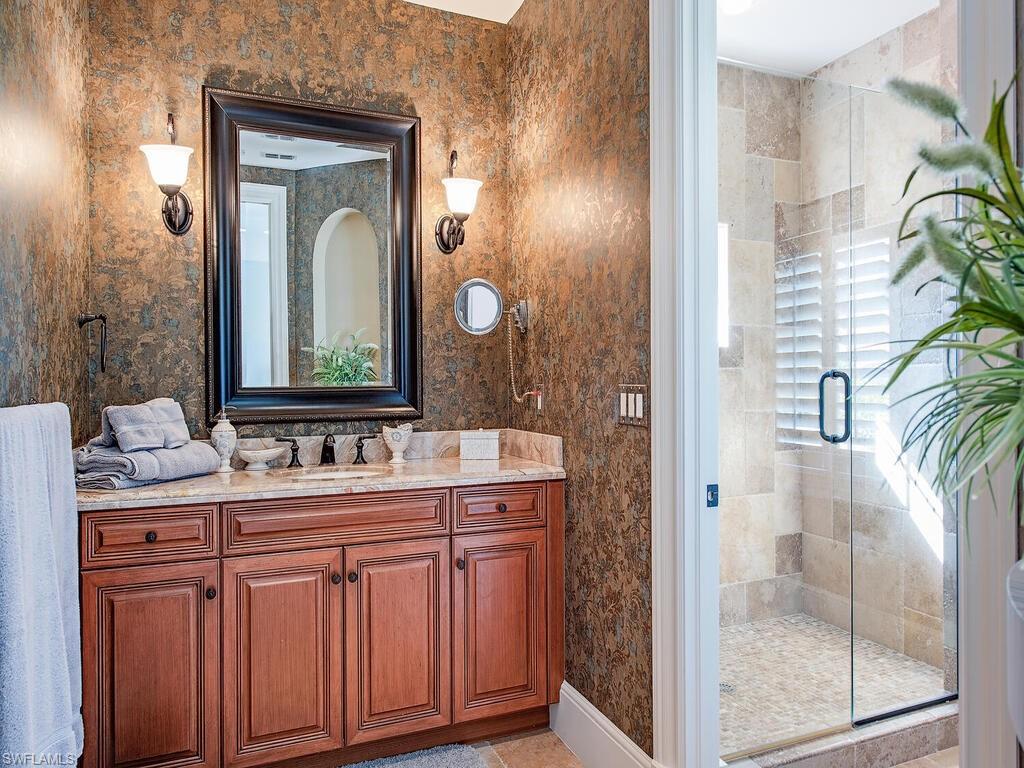 155 20th Avenue South Naples, FL 34102 - Photo 15 of 30 Full bath featuring a stall shower, vanity, light tile patterned flooring, and wallpapered walls