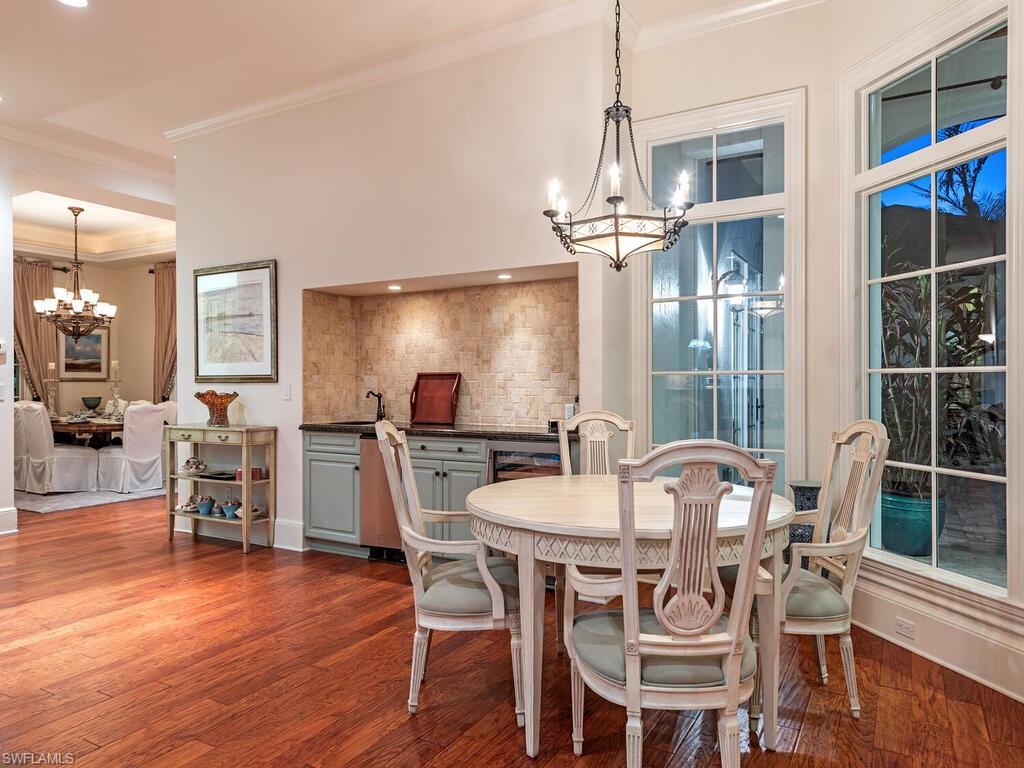 155 20th Avenue South Naples, FL 34102 - Photo 20 of 30 Dining space with a chandelier, crown molding, and dark wood-style floors