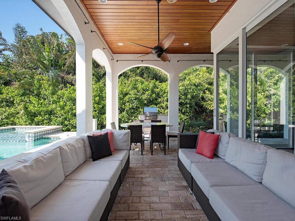 155 20th Avenue South Naples, FL 34102 - Photo 3 of 30 View of patio / terrace with outdoor dining area, outdoor lounge area, a ceiling fan, an outdoor kitchen, and a pool with connected hot tub