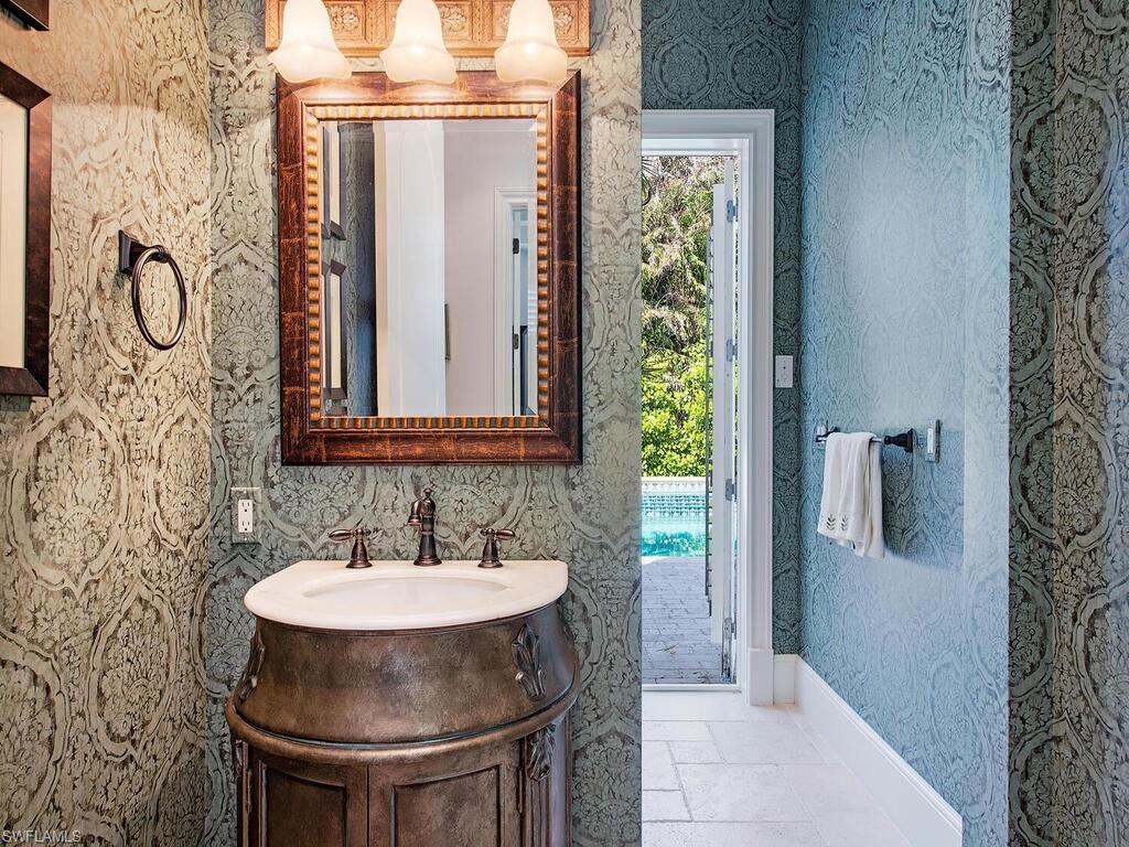 155 20th Avenue South Naples, FL 34102 - Photo 5 of 30 Bathroom featuring wallpapered walls, vanity, and stone tile flooring