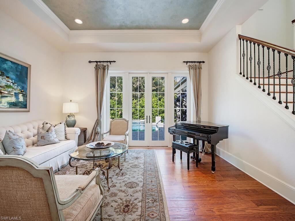 155 20th Avenue South Naples, FL 34102 - Photo 6 of 30 Living room with hardwood / wood-style floors, stairs, french doors, a raised ceiling, and ornamental molding