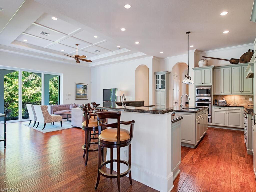 155 20th Avenue South Naples, FL 34102 - Photo 29 of 30 Kitchen with arched walkways, recessed lighting, open floor plan, decorative backsplash, and dark stone countertops