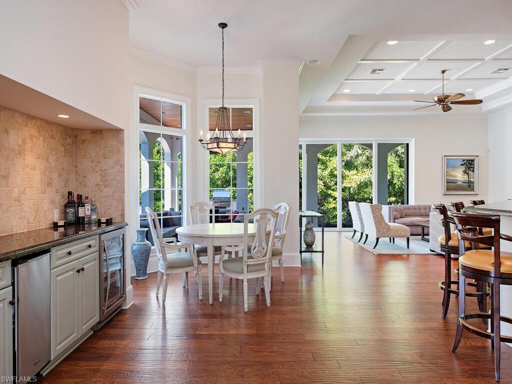 155 20th Avenue South Naples, FL 34102 - Photo 8 of 30 Dining space featuring plenty of natural light, beverage cooler, recessed lighting, dark wood-type flooring, and a chandelier