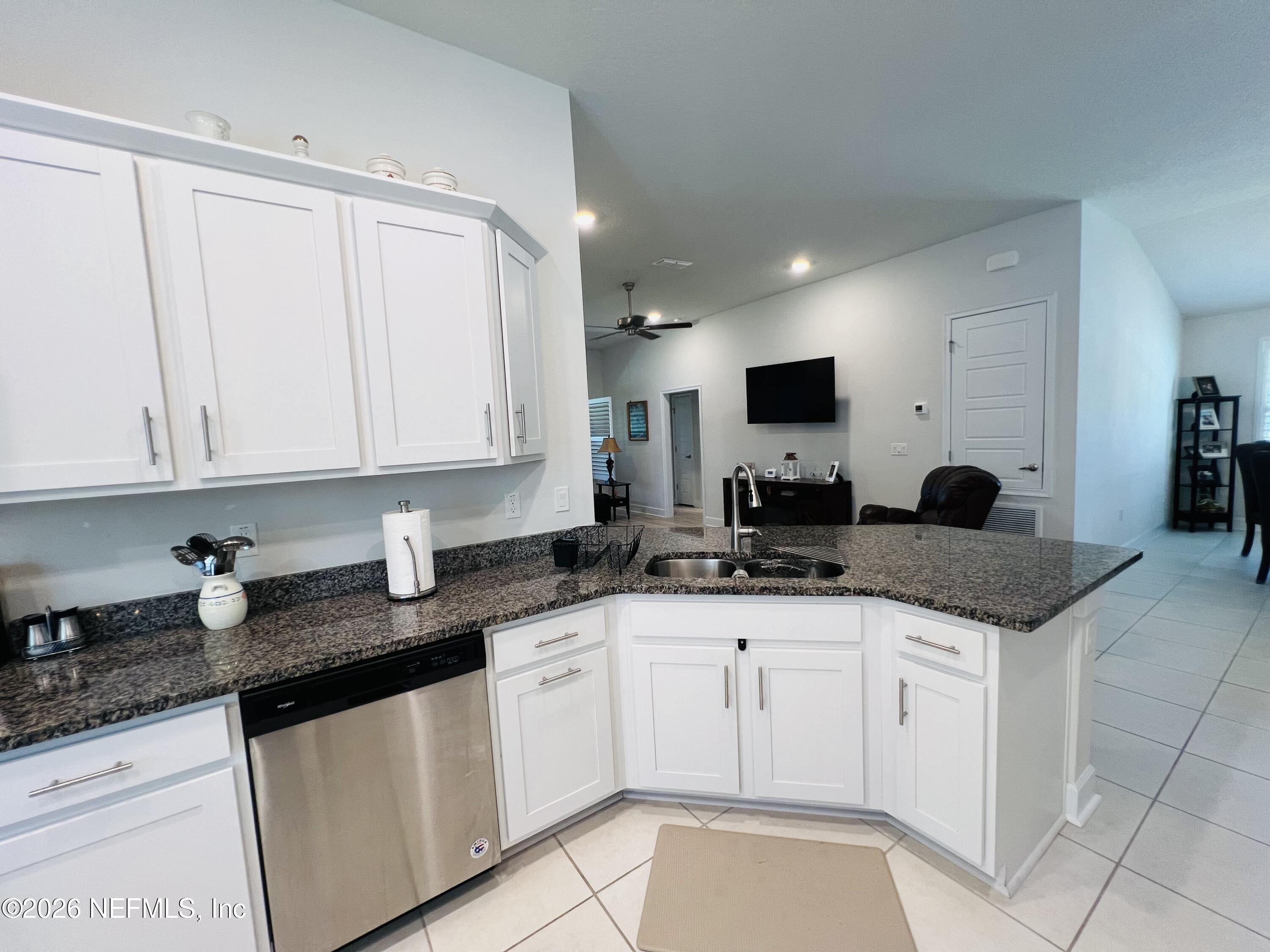 2 Rivertown Road Palm Coast, FL 32137 - Photo 40 of 80 a kitchen with granite countertop white cabinets sink and stainless steel appliances