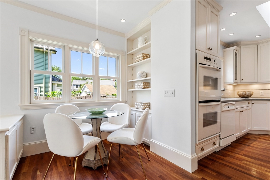 8 Jackson Court Lexington, MA 02421 - Photo 12 of 27 a kitchen with stainless steel appliances granite countertop a stove a refrigerator a kitchen island a dining table and chairs with wooden floor