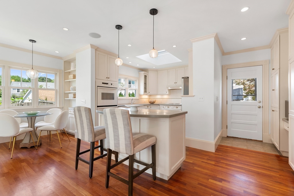 8 Jackson Court Lexington, MA 02421 - Photo 8 of 27 a kitchen with stainless steel appliances a dining table chairs stove and wooden floor