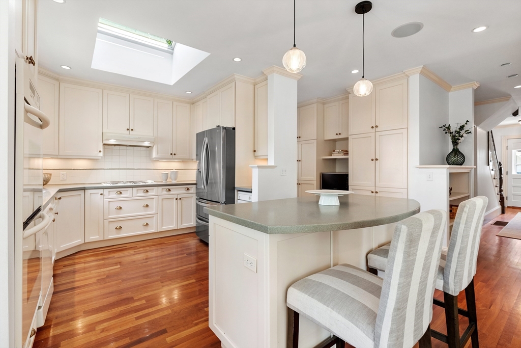 8 Jackson Court Lexington, MA 02421 - Photo 9 of 27 a kitchen with stainless steel appliances granite countertop a sink a stove a refrigerator and island with wooden floor
