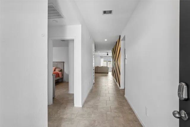 a view of a hallway with closet and a bathroom