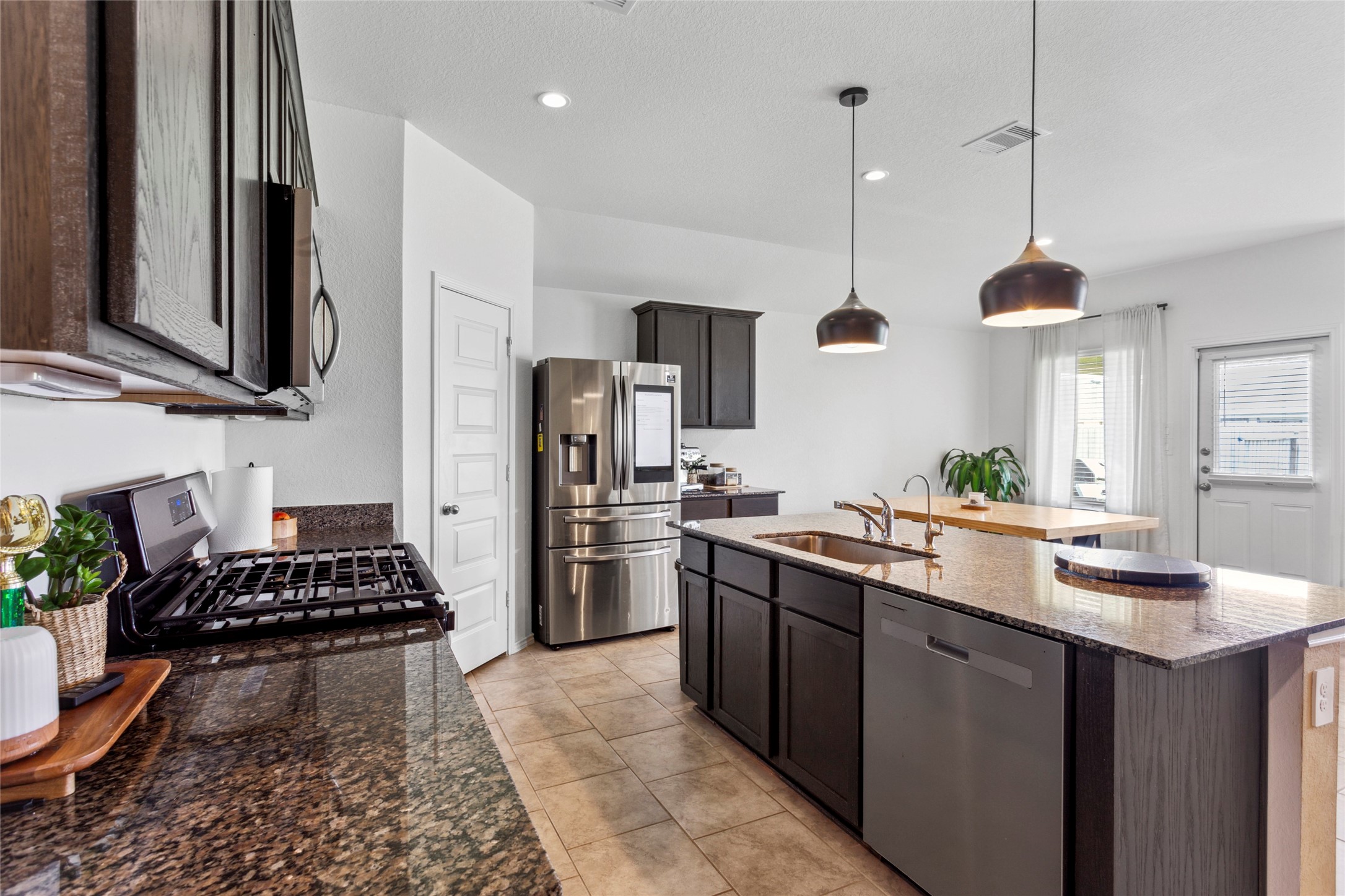 7510 Carson Court Rosharon, TX 77583 - Photo 6 of 23 a kitchen with refrigerator a stove a sink and a microwave