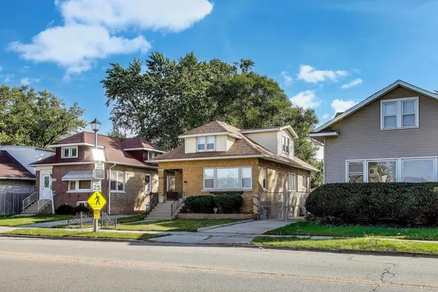 a view of a brick house with a yard garden and plants