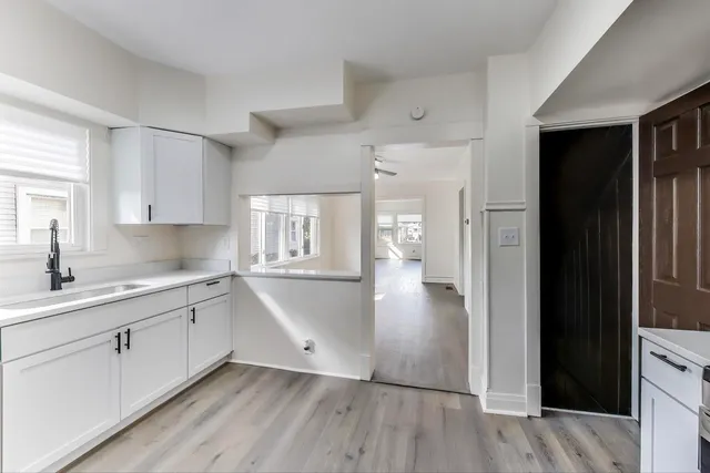 a view of kitchen with sink and refrigerator