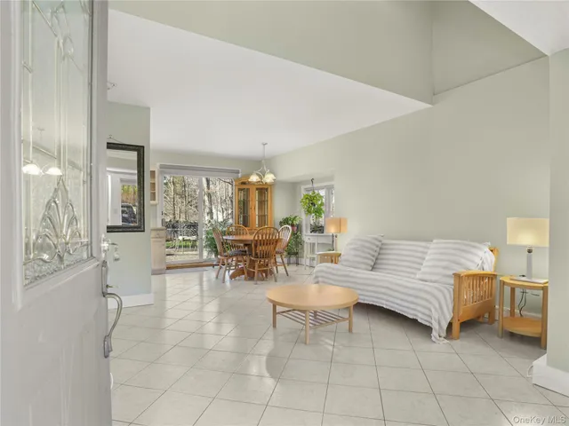 a living room with furniture and a dining table with chairs