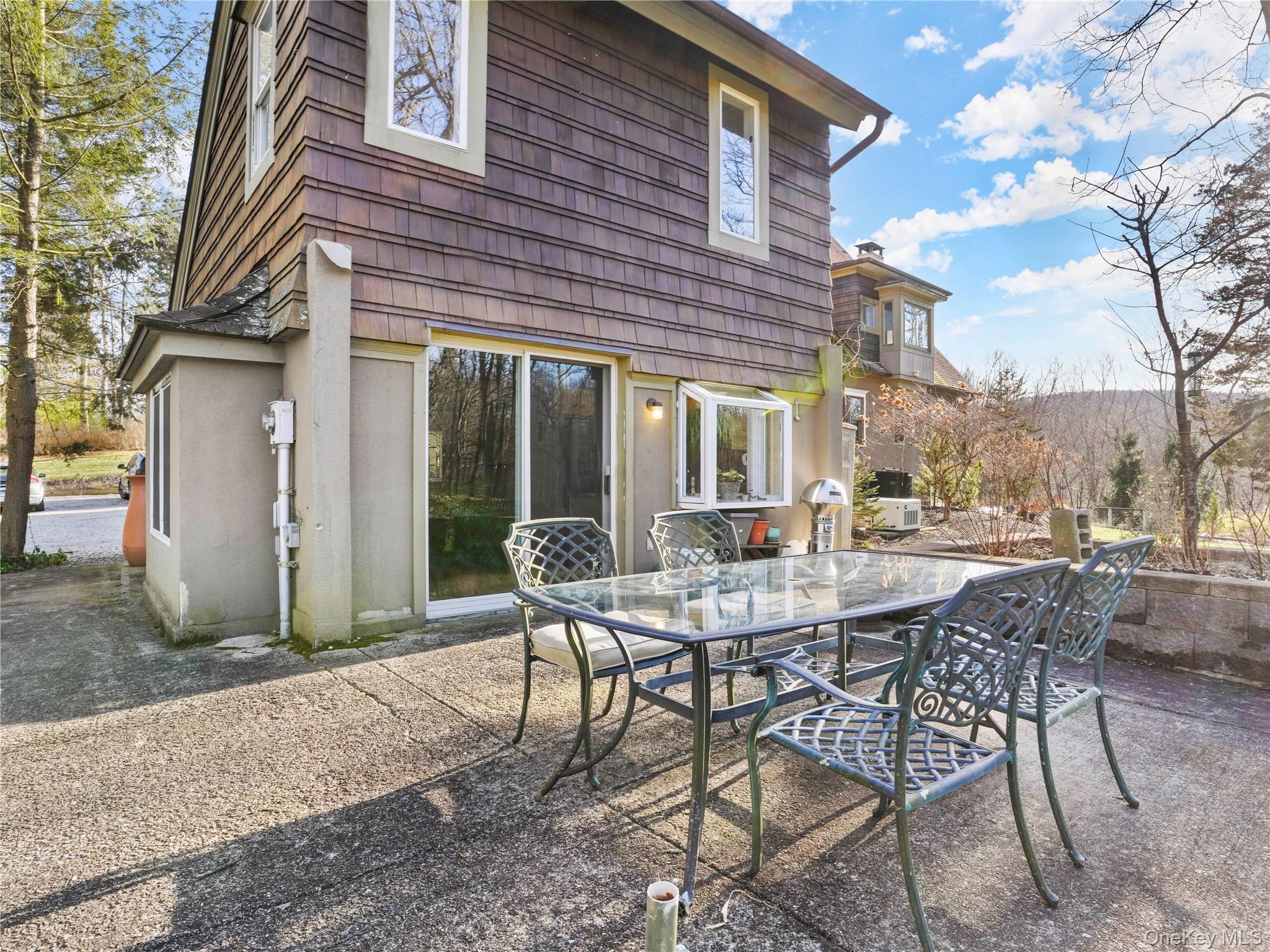 290 Salem Road Pound Ridge, NY 10576 - Photo 20 of 21 a view of a patio with a table and chairs and floor to ceiling window