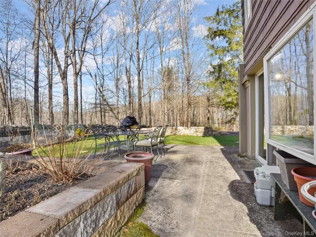 a view of a swimming pool with a patio and a yard