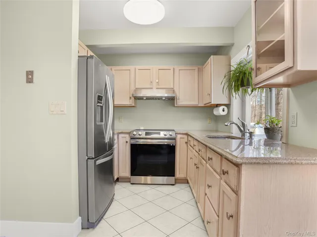 a kitchen with stainless steel appliances granite countertop a refrigerator sink and stove