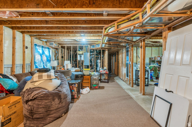 1727 South Sandhill Road Orem, UT 84058 - Photo 24 of 27 Unfinished basement featuring exposed wood framing, an open ceiling with visible joists, and existing carpeted flooring
