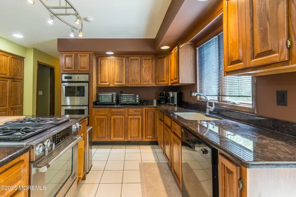 a kitchen with stainless steel appliances granite countertop a stove sink and cabinets