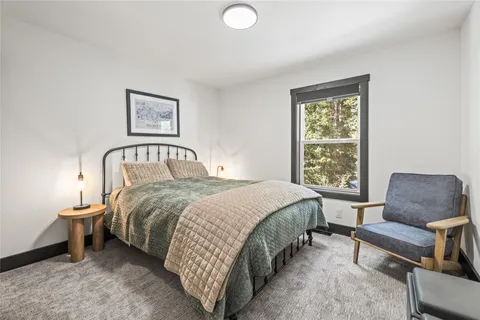 a bedroom with a bed chair and window