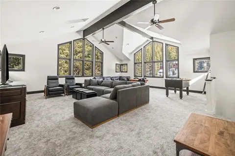 a living room with furniture large windows and a flat screen tv