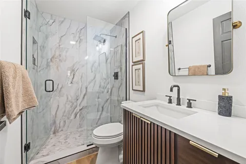 a bathroom with a sink a toilet and shower