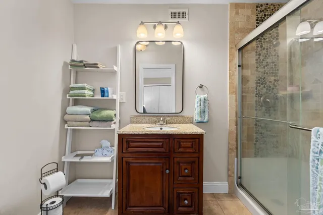 a bathroom with a granite countertop sink a toilet and shower