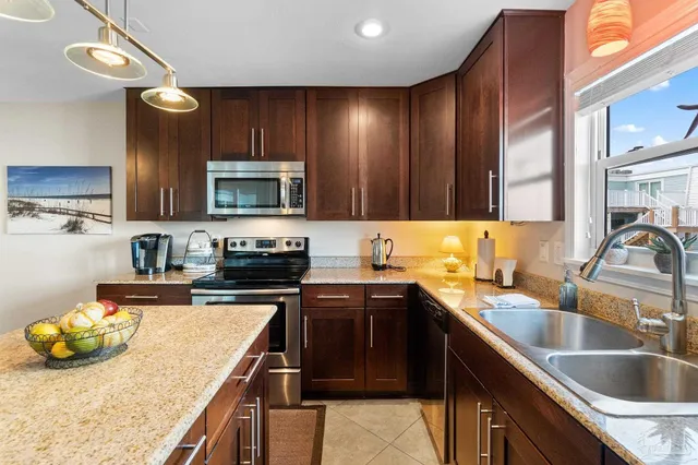 a kitchen with kitchen island granite countertop a sink stove and cabinets