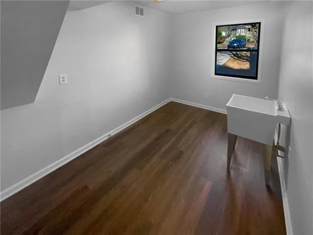 a view of a workspace with wooden floor