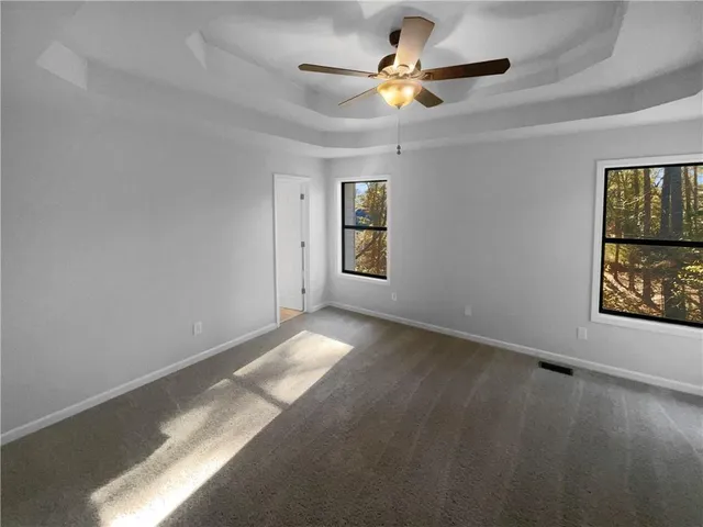 an empty room with a window and a ceiling fan