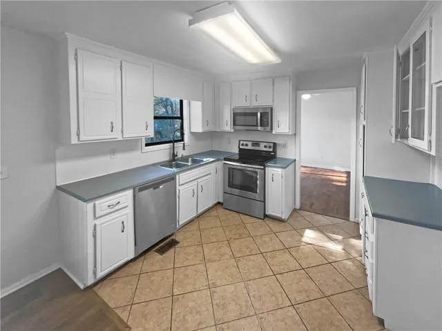 a kitchen with stainless steel appliances a sink a stove a microwave and cabinets