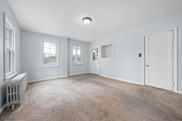 an empty room with windows and closet