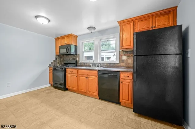 a kitchen with stainless steel appliances granite countertop a refrigerator a stove a sink and a refrigerator