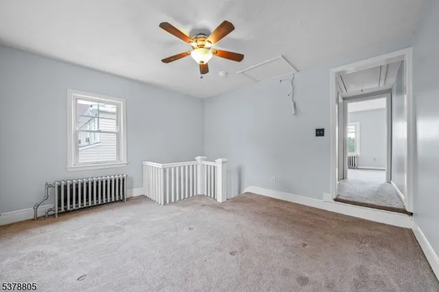 an empty room with windows and ceiling fan