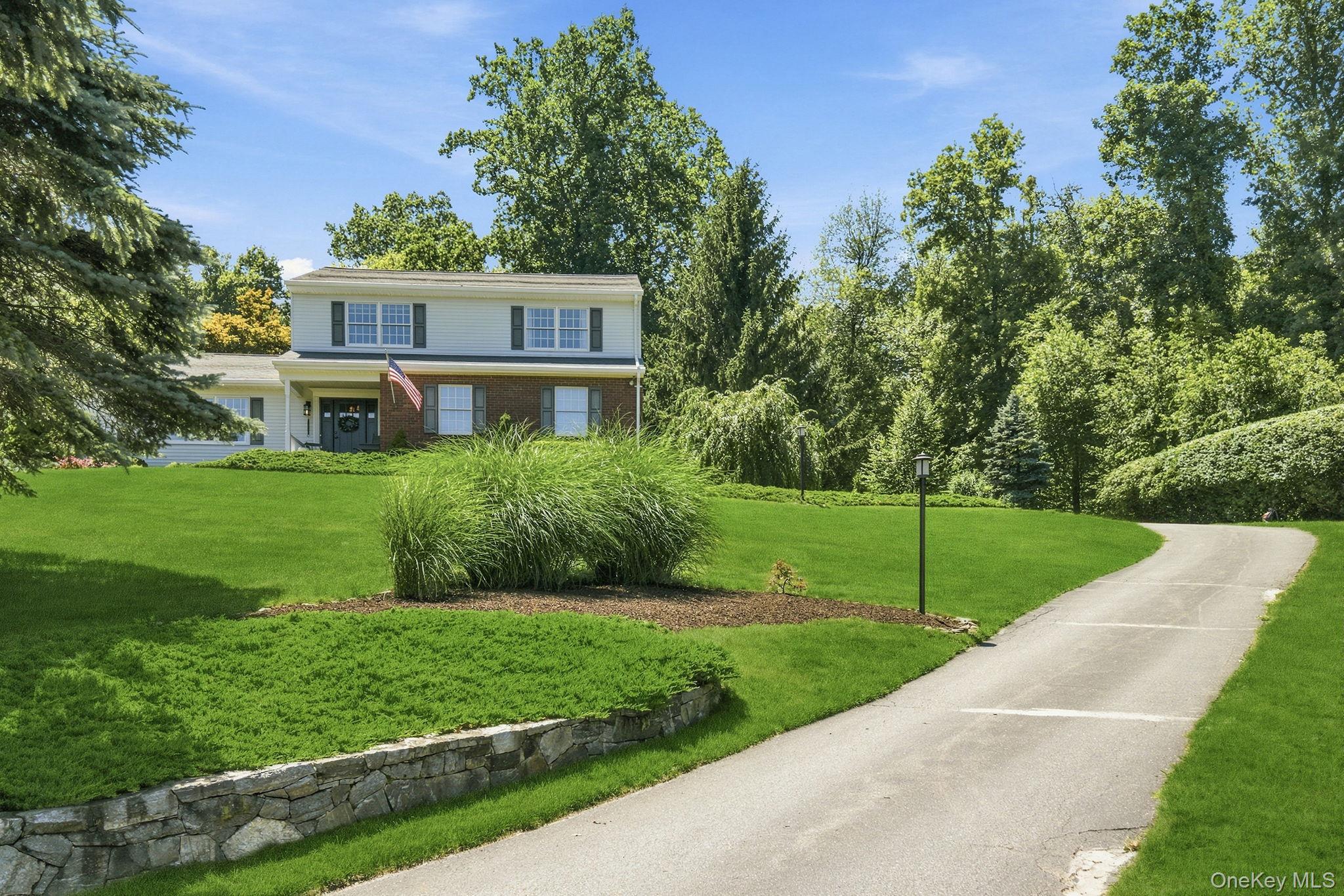 32 Bedell Road Katonah, NY 10536 - Photo 46 of 49 A lamppost-lit paved driveway winds past stone retaining walls.