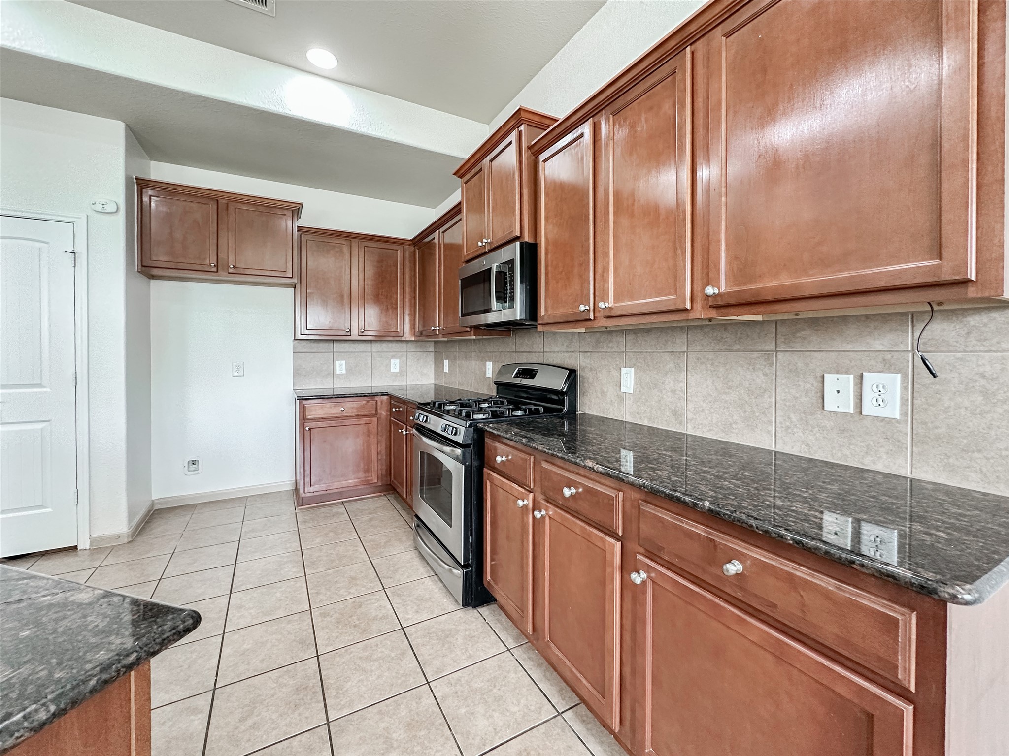 20319 Little Wing Drive Spring, TX 77388 - Photo 25 of 49 a kitchen with stainless steel appliances granite countertop a stove a sink and a microwave