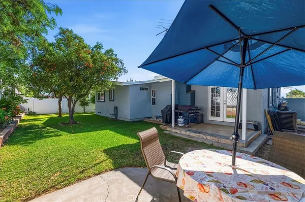 a view of a patio with a table and chairs under an umbrella