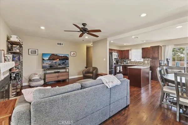 a living room kitchen with furniture and a wooden floor