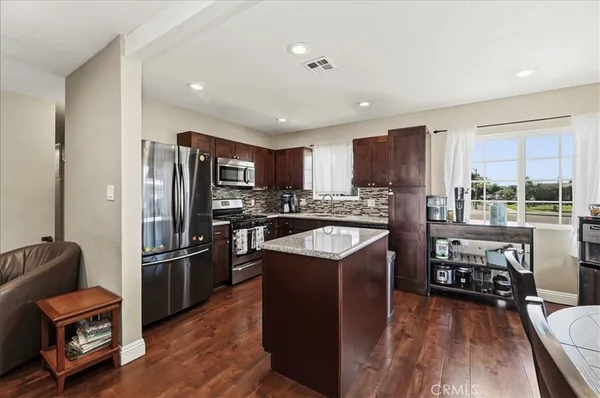 a kitchen with stainless steel appliances granite countertop a refrigerator stove microwave and sink