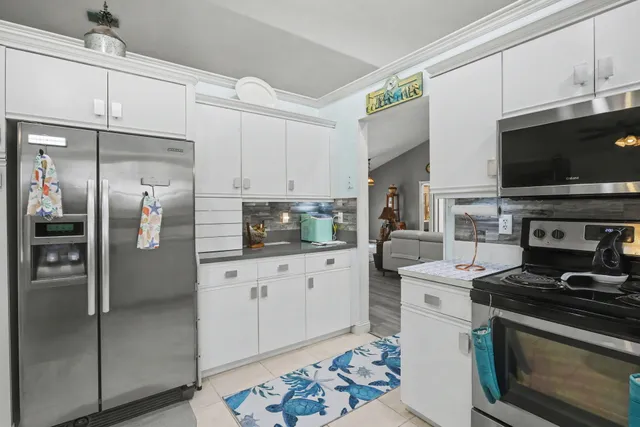 a kitchen with stainless steel appliances granite countertop a sink refrigerator and cabinets